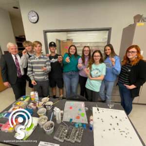 Superintendent stands with jewelry class Students