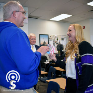 Superintendent looks on as Candice Pierucci looks at her "sample work"