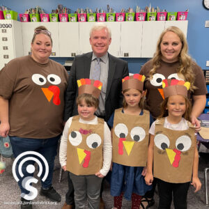 Superintendent with teachers and students in their turkey outfits